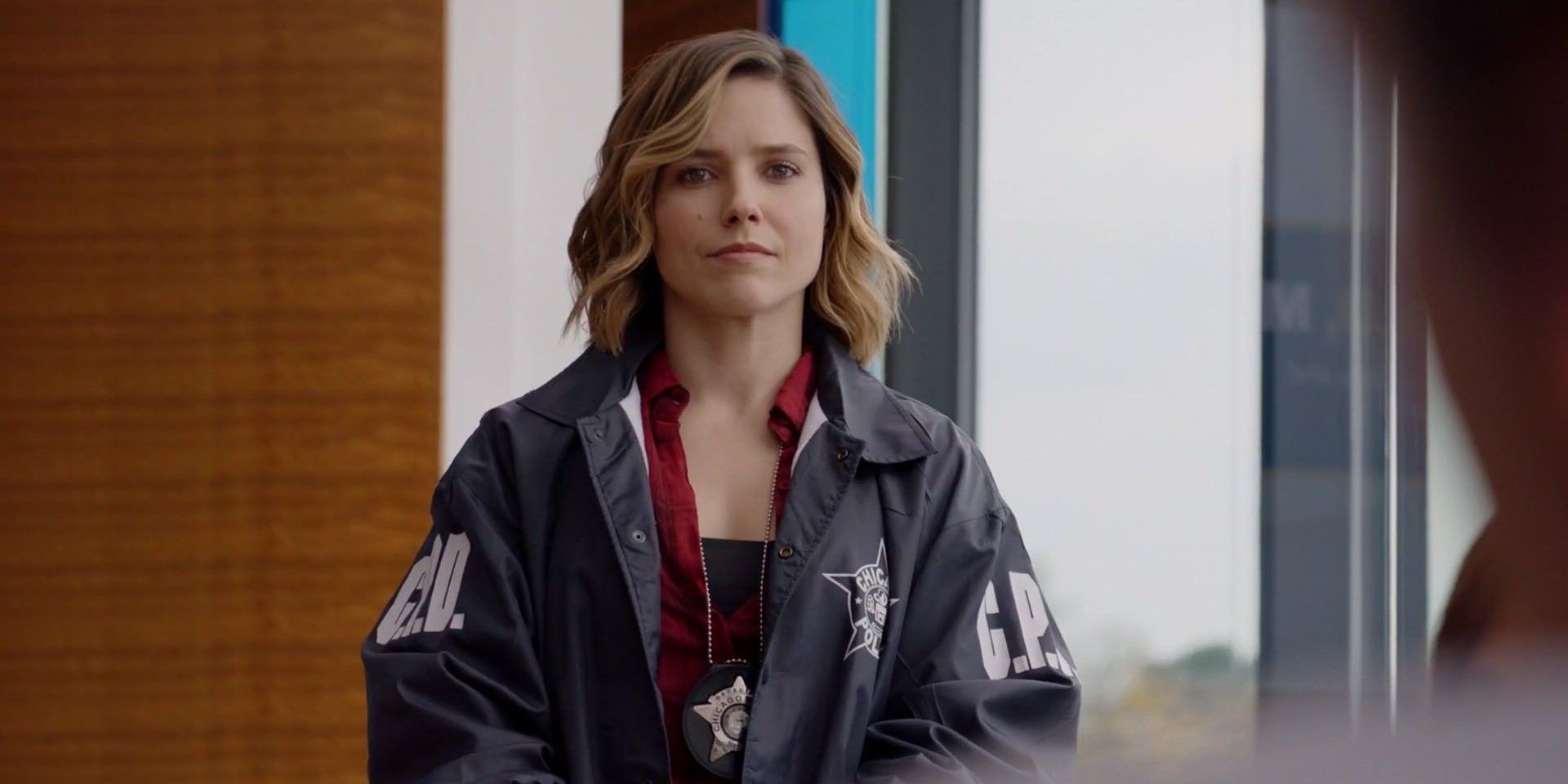 Erin Lindsay looks at the audience in her police jacket in Chicago PD