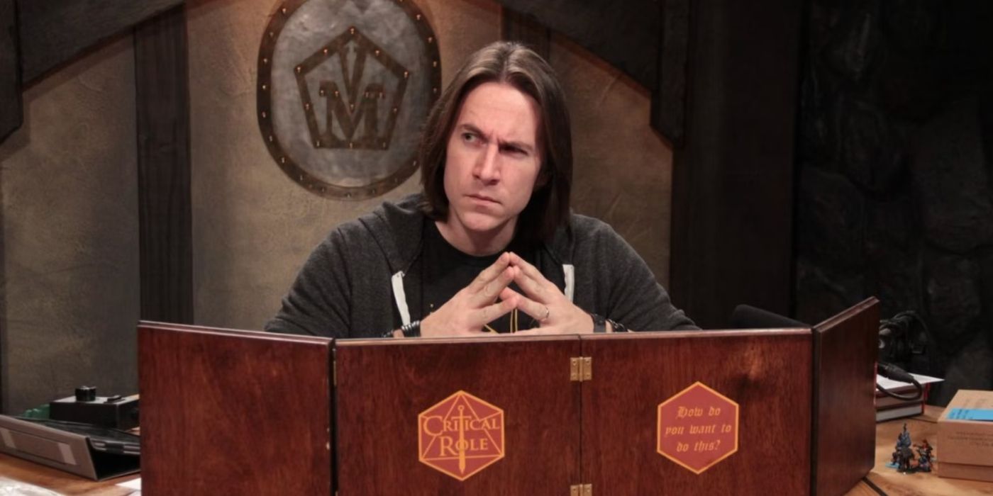 Papel crítico DM Matthew Mercer olhando por cima de uma tela DM DnD