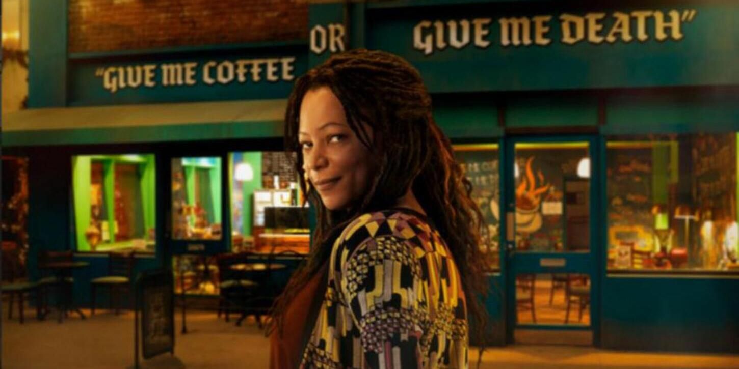 Nina standing outside of her coffee shop in Good Omens.