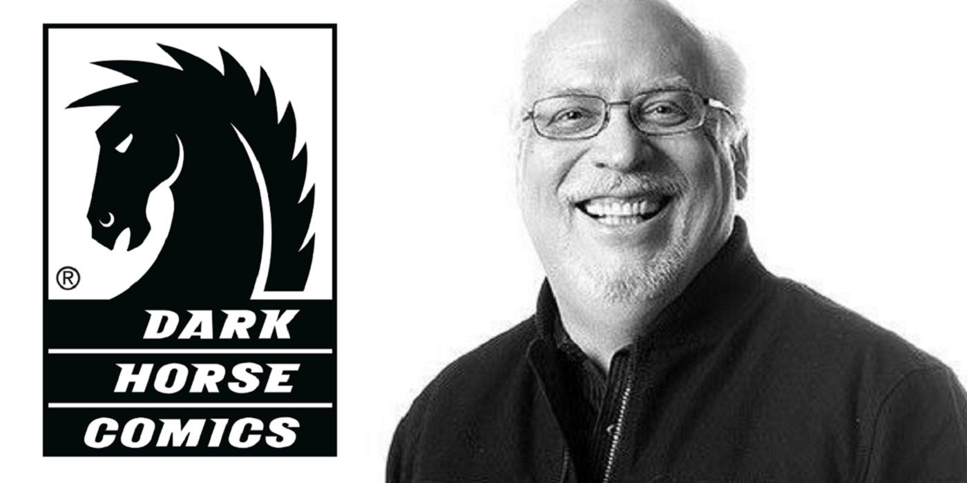 J. Michael Straczynski poses next to the Dark Horse Comics' logo