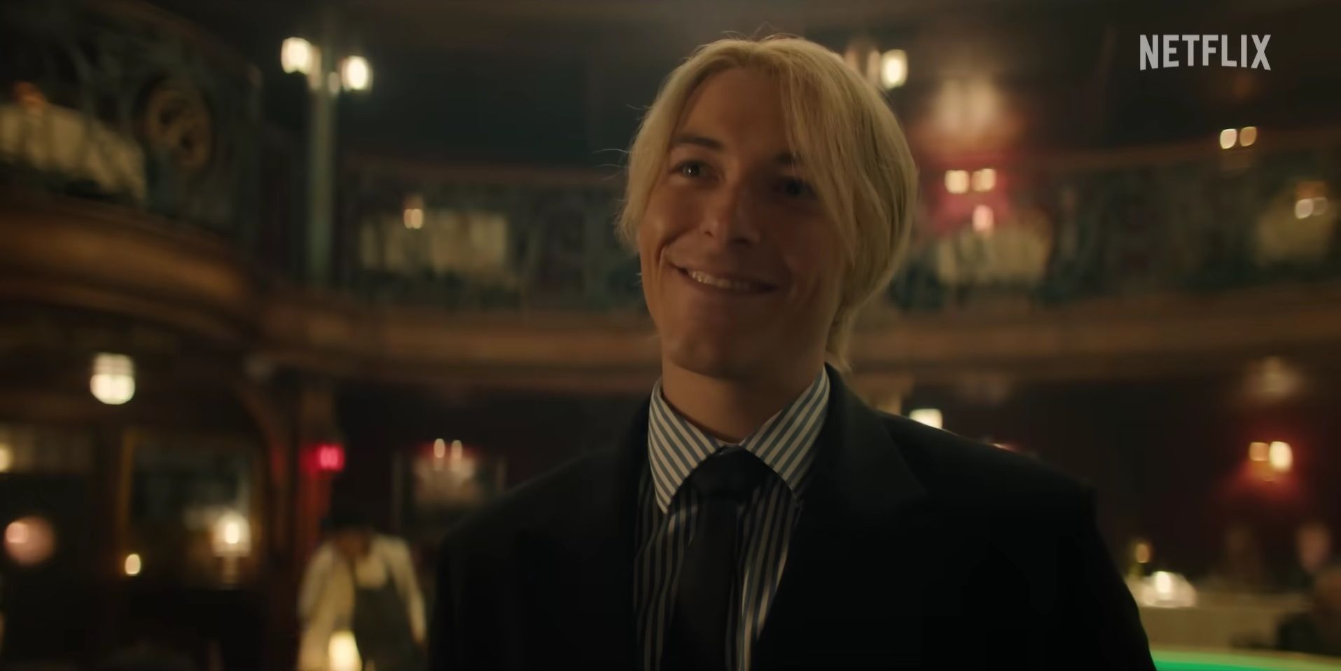 Sanji, played by taz skylar in the Netflix one piece live action, smiles in the Baratie