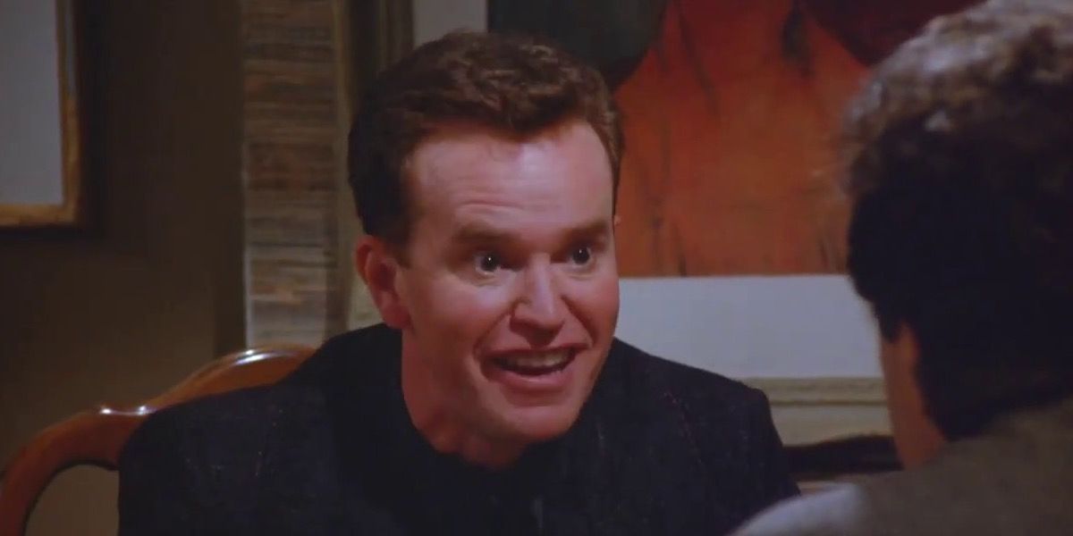 Kenny Bania smiling while having dinner with Jerry in Seinfeld