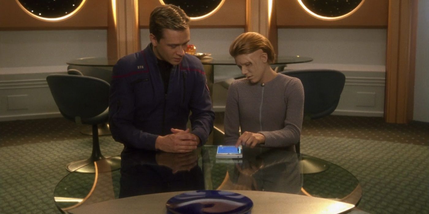 Trip Tucker sentado com o cogenitor do episódio de mesmo nome em Star Trek Enterprise