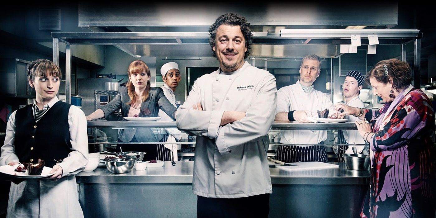 O chef dos Brancos posando em frente à cozinha, com sua equipe atrás dele.