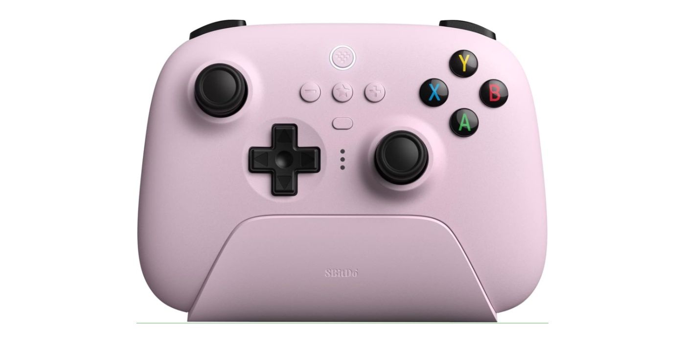 The Pastel Pink variant of the 8Bitdo Ultimate Controller on its charging dock.
