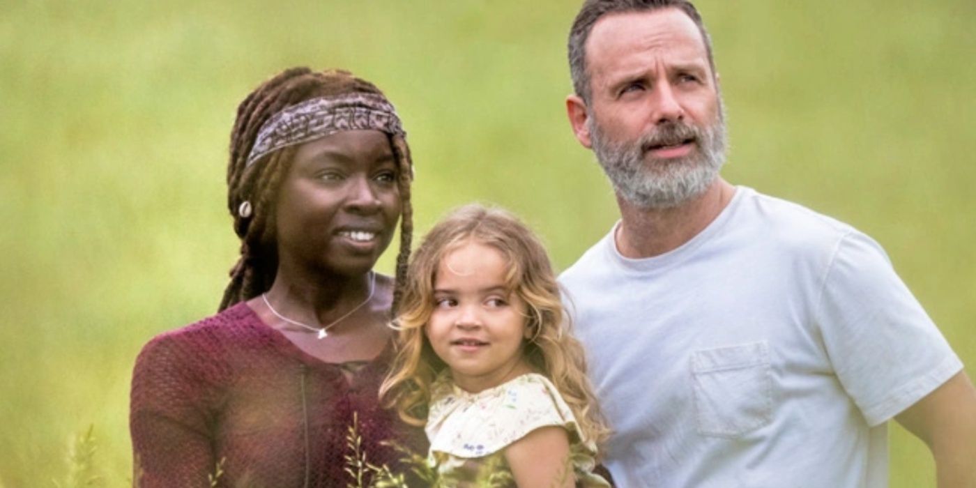 Michonne holding Judith and standing with Rick in The Walking Dead. 