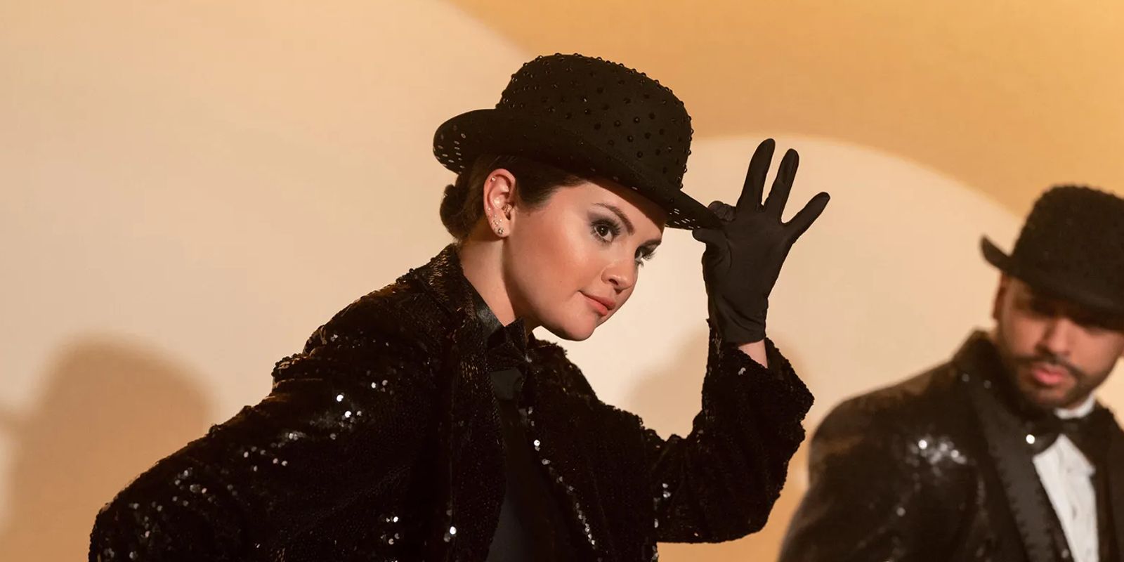 Selena Gomez como Mabel no palco, dançando e segurando o chapéu em Only Murders in the Building 3ª temporada