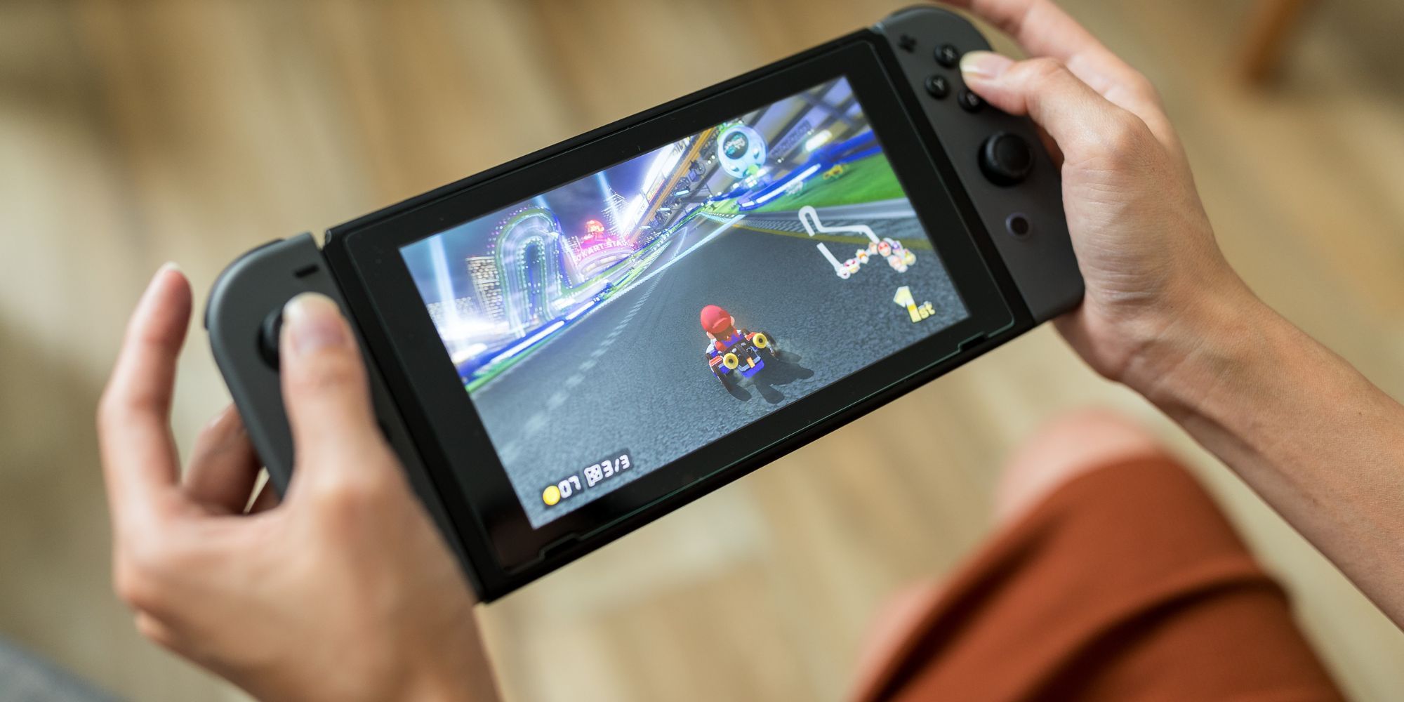 Uma pessoa jogando Mario Kart no Nintendo Switch no modo portátil