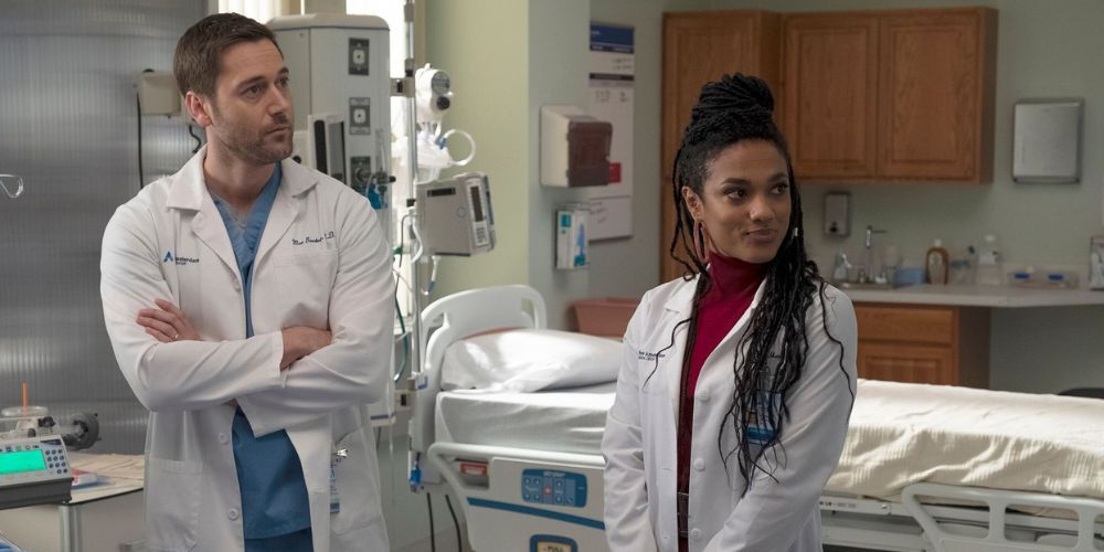 Ryan Eggold como Max Goodwin e Freema Agyeman como Helen Sharpe estão juntos em um quarto de hospital em Nova Amsterdã.