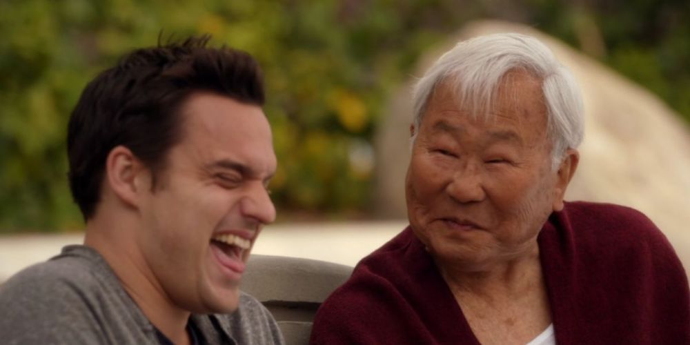 Nick laughing and Tran smiling in New Girl