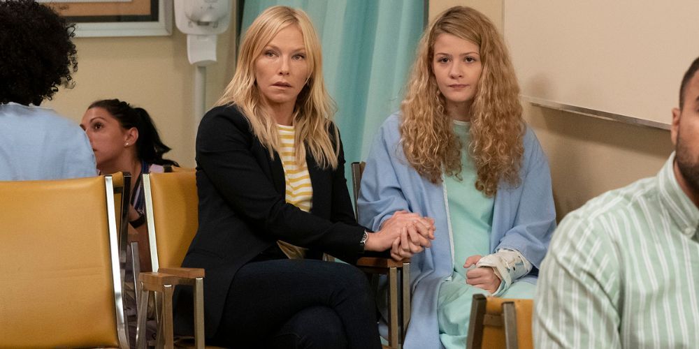 Kelli Giddish como Amanda Rollins senta-se com Kira McLean como Evangeline Miller na sala de espera de um hospital em Law & Order: SVU.