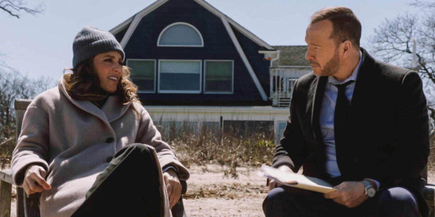 Jackie and Danny sitting on the beach in front of a house on Blue Bloods
