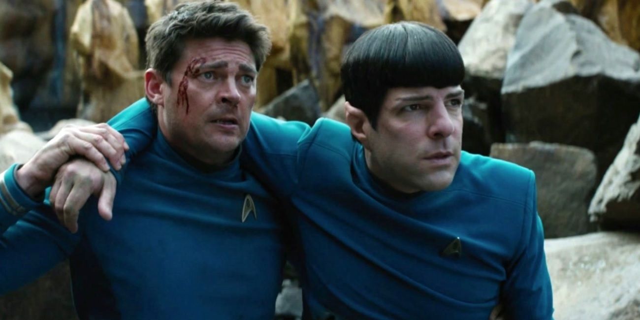 Karl Urban's Leonard McCoy with a gash on his forehead supporting Zac Quinto's Spock