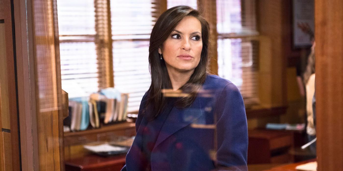 Mariska Hargitay as Olivia Benson stands at a window with an office behind her on Law & Order: SVU.