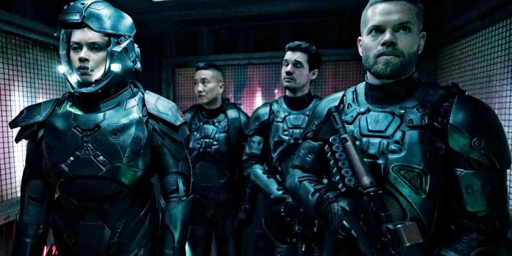 Um quarteto de oficiais fica parado enquanto usa trajes espaciais blindados em The Expanse