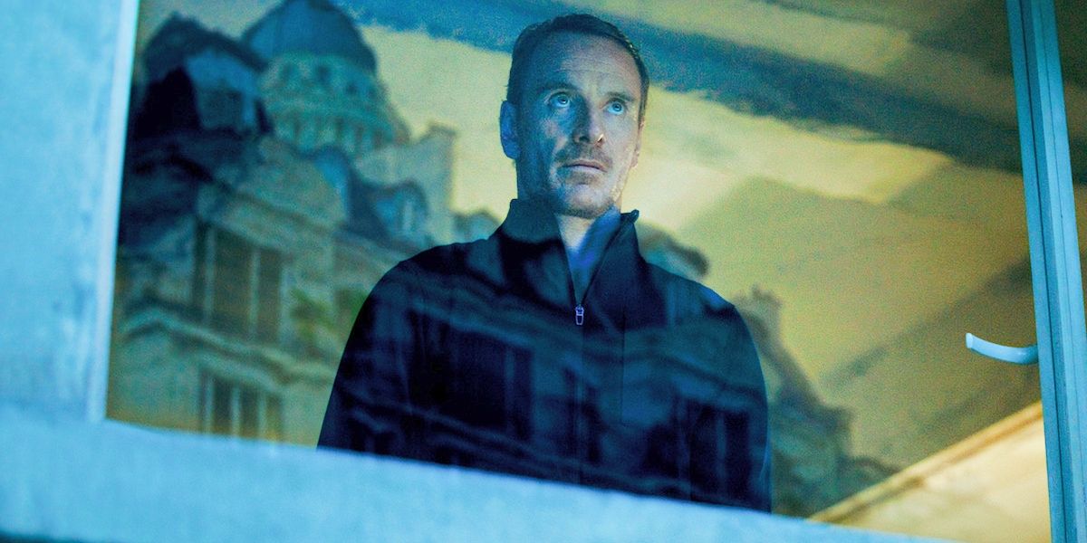 The Killer (Michael Fassbender) stares menacingly out a window in The Killer
