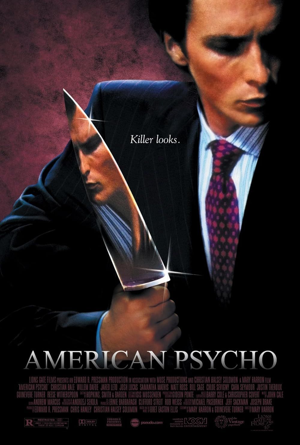 Christian Bale as Patrick Bateman holding a knife with a reflection on American Psycho movie poster