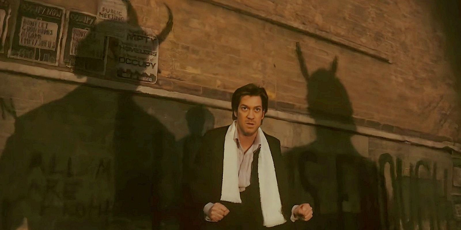 Brad Wolfe in a tuxedo against a brick wall with two horned shadows of Loki behind him