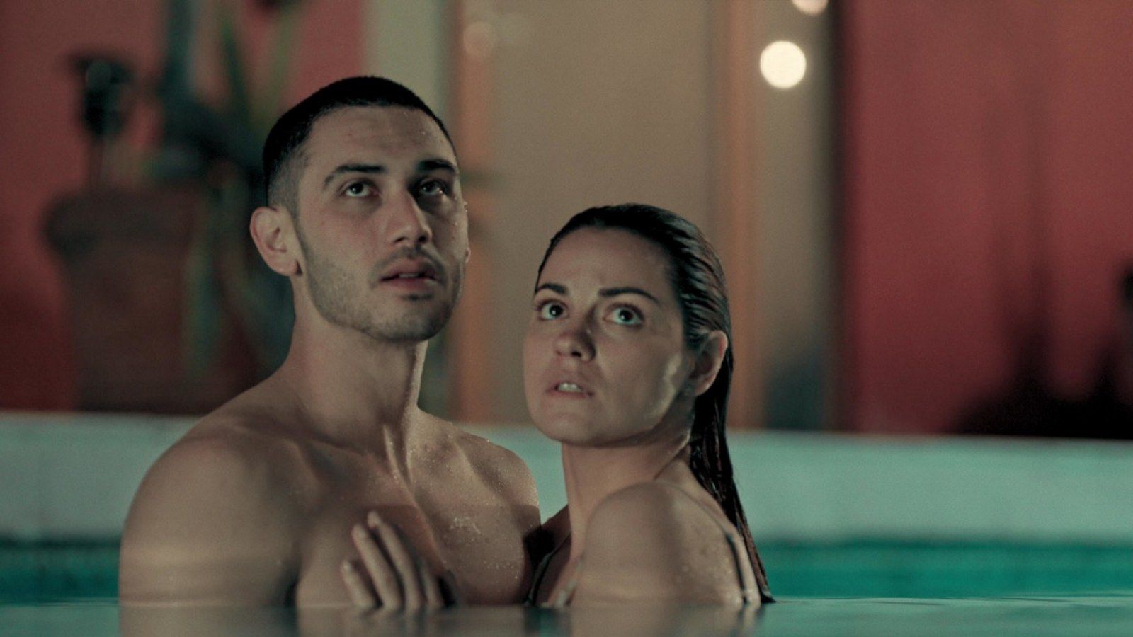 Esteban and Alma stand in a pool.