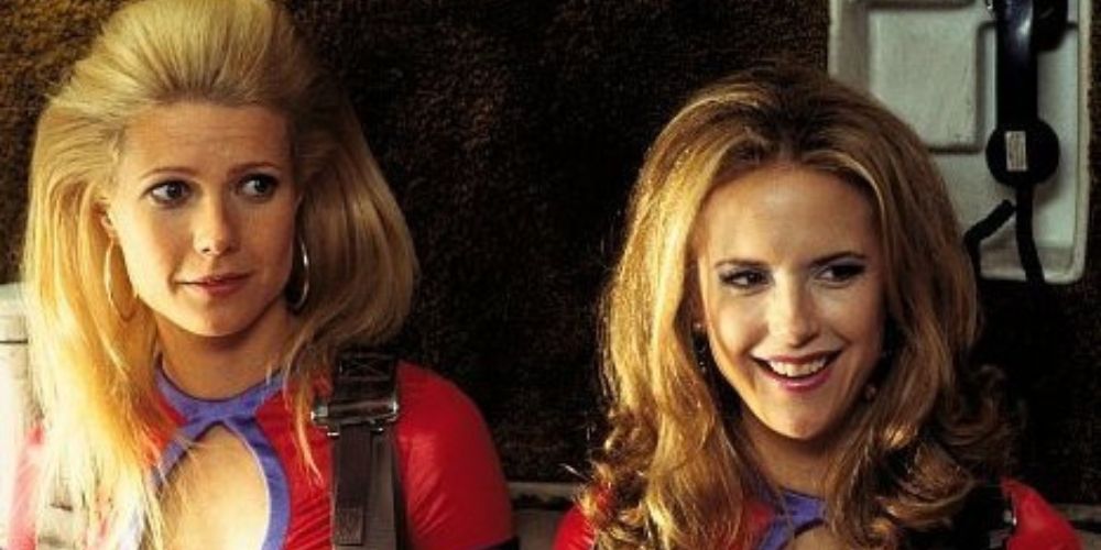 Gwyneth Paltrow as Donna Jensen and Kelly Preston as Sherry sit together as flight attendants on a plane in View from the Top
