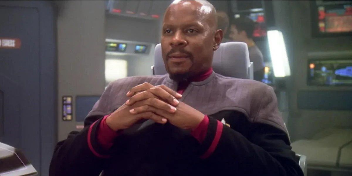 Captain Benjamin Sisko sitting on the bridge of the Defiant in Star Trek Deep Space Nine