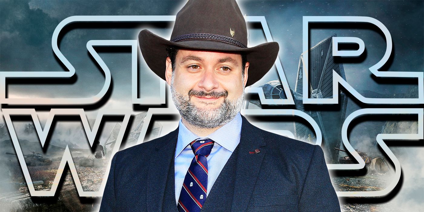 Dave Filoni stands in front of a logo for Star Wars