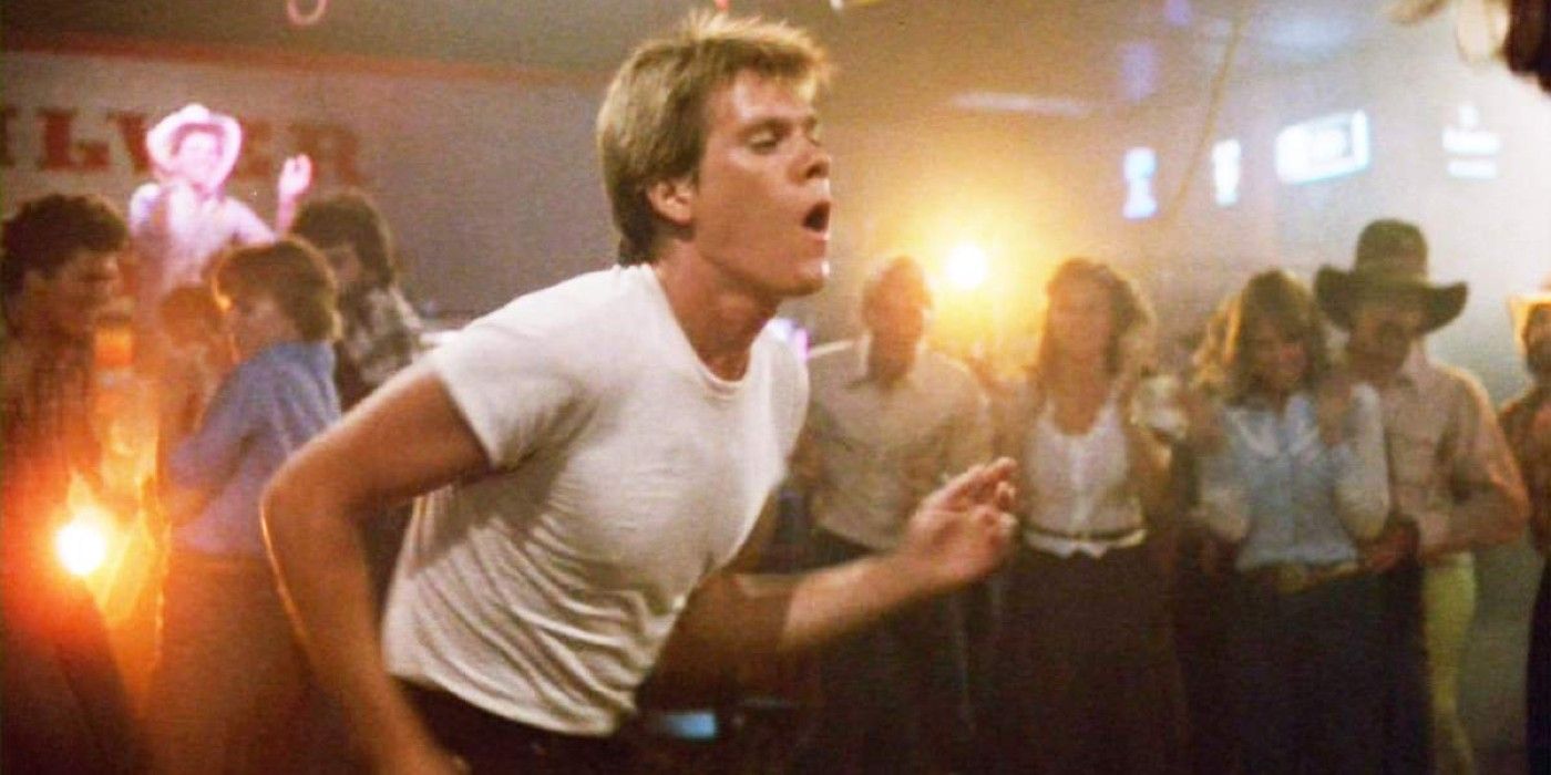 Kevin Bacon in a white shirt dancing in front of a crowd in Footloose movie