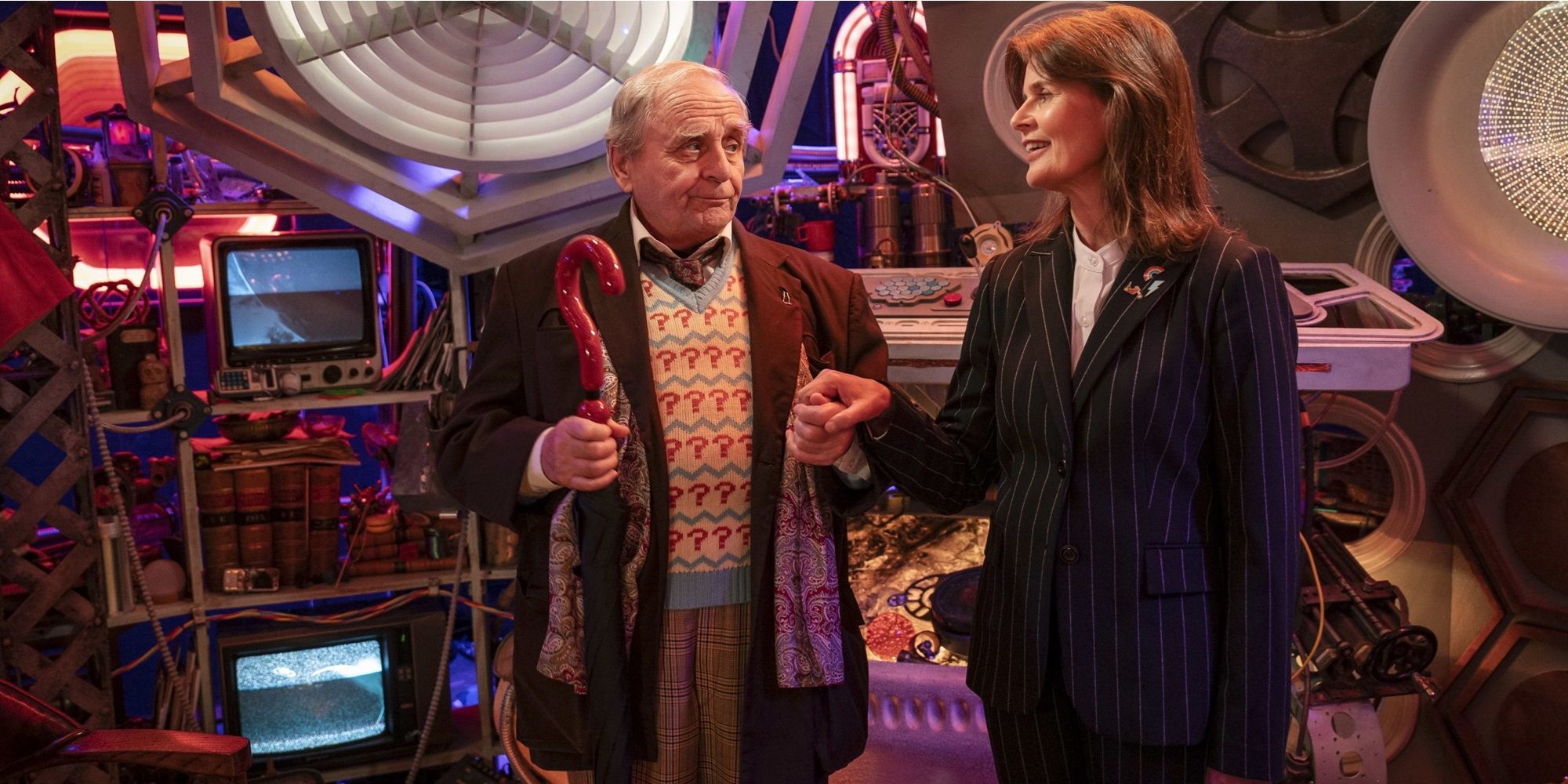 The Seventh Doctor standing, holding a close umbrella in one hand and taking Ace, standing dressed in a pinstripe suit, by the hand in Doctor Who TAles of the TARDISjpg