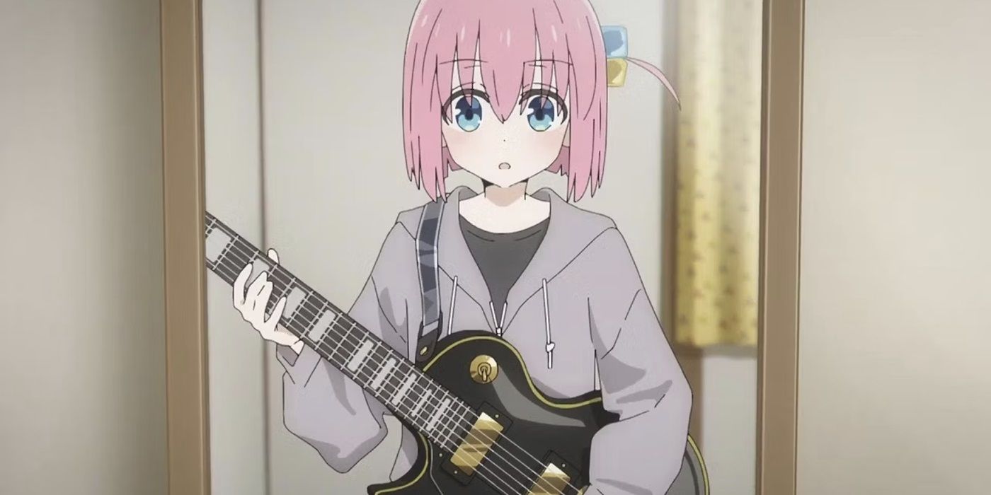 Hitori Goto from the Bocchi the Rock anime holding a guitar and looking in a mirror