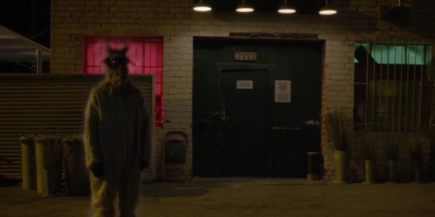 Goatman, “Rusty” stands ominously in an alley with glowing red eyes. 