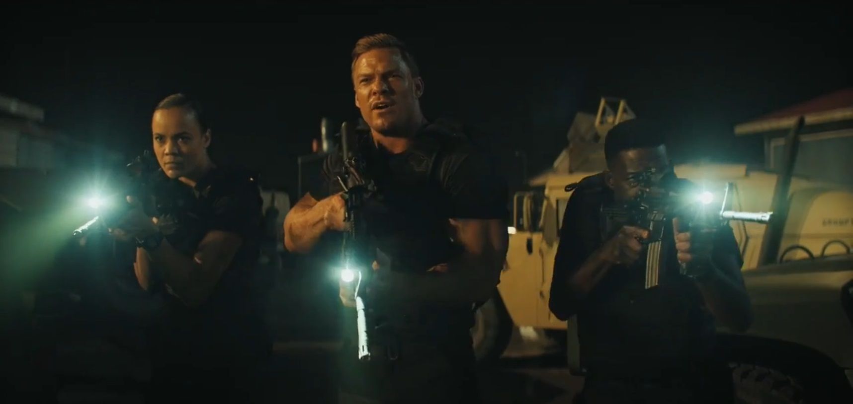 Frances Neagley, Jack Reacher and Stan Lowrey dressed in black aiming rifles with flashlights in the motor pool in Season 2