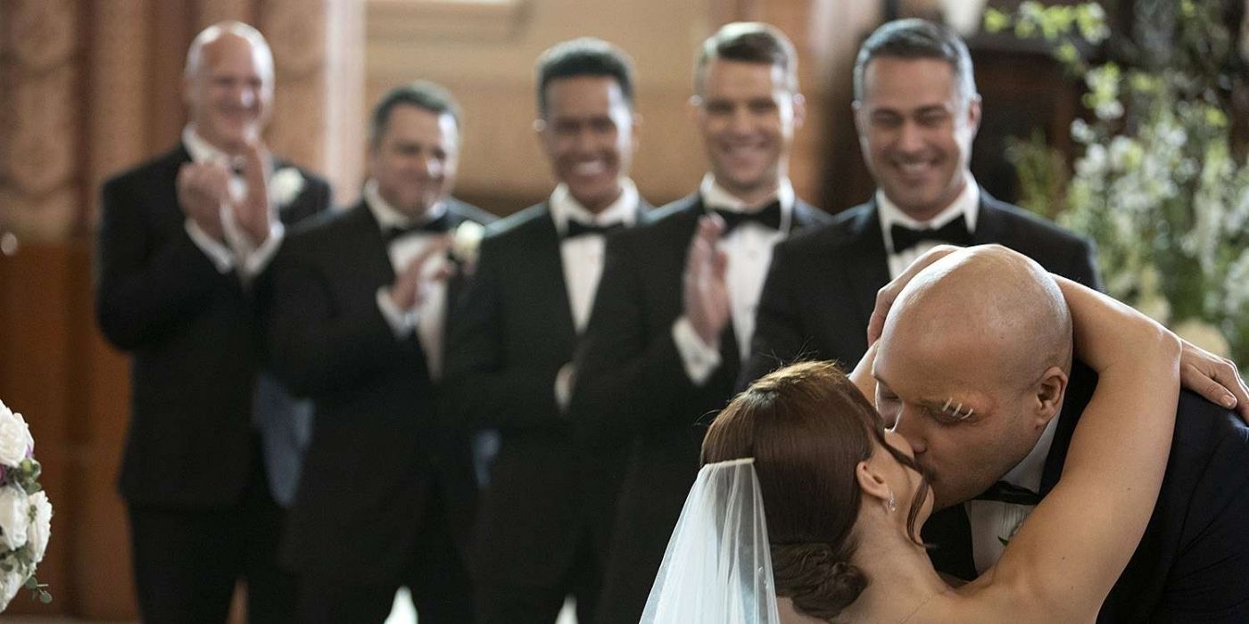 Joe Minoso as Joe Cruz kisses Kristen Gutoskie as Chloe Cruz with Taylor Kinney as Kelly Severide, Jesse Spencer as Matt Casey, Jeff Lima as Leon Cruz, Anthony Ferraris as Tony Ferraris, and Randy Flagler as Harold Capp behind him on