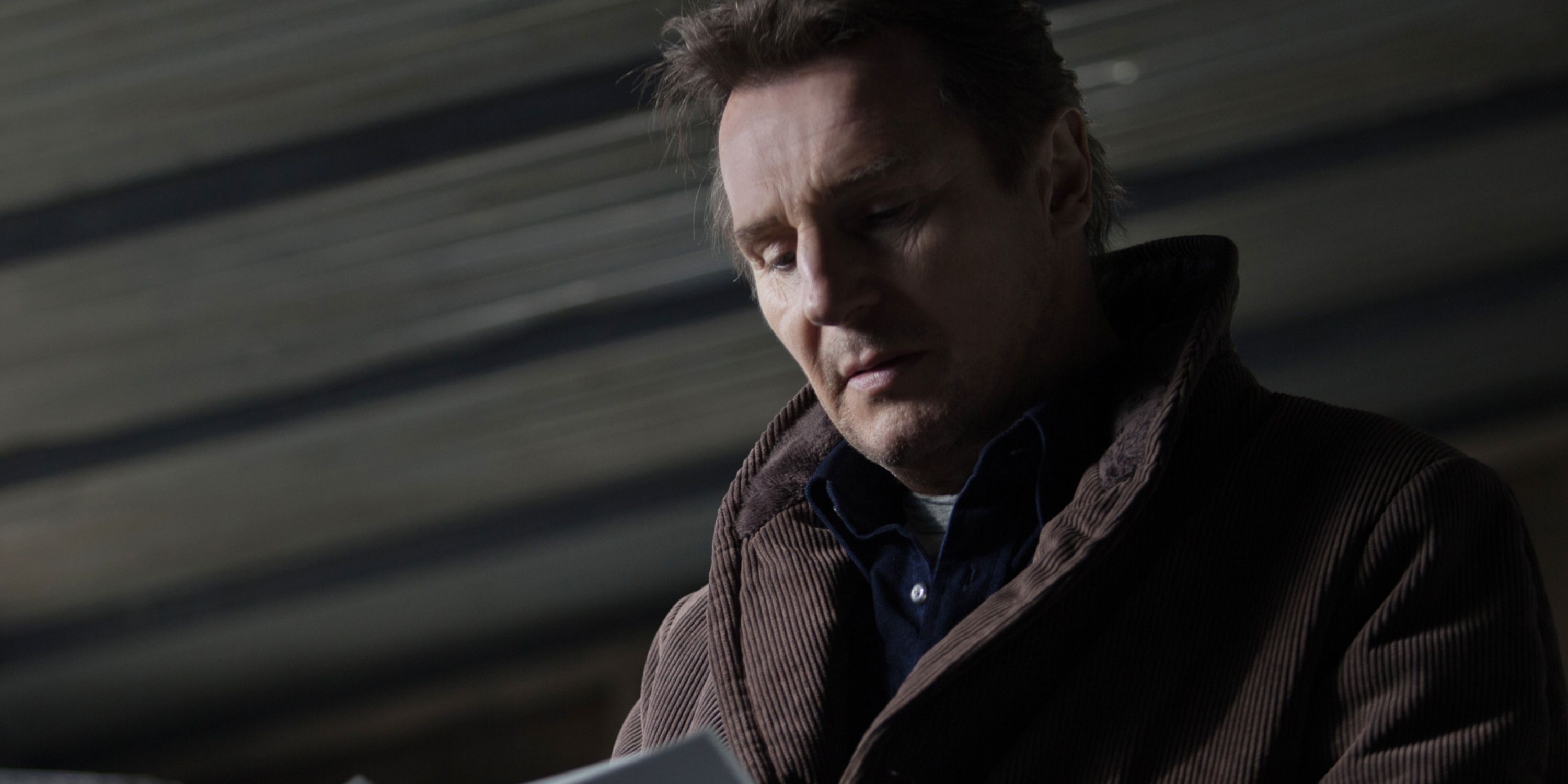 Matt Scudder (Liam Neeson) reads a notebook in A Walk Among the Tombstones