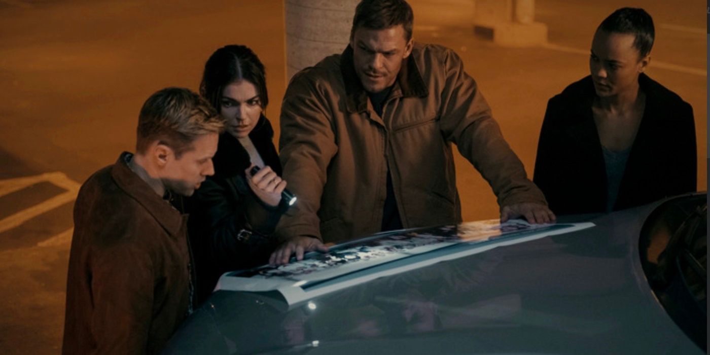 O'Donnell, Dixon, Reacher and Neagley looking at large photo on the hood of a truck