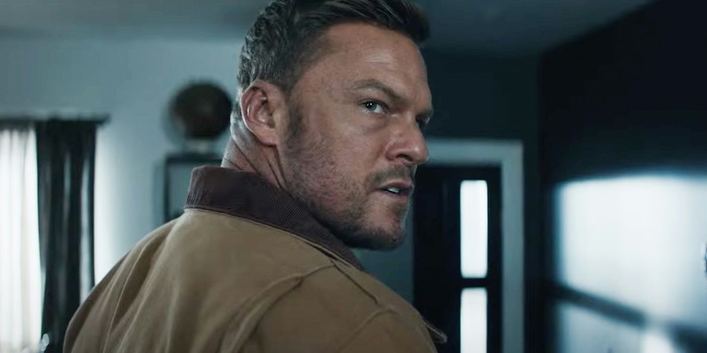 Reacher looking over his shoulder with an angry expression in Shaw's house