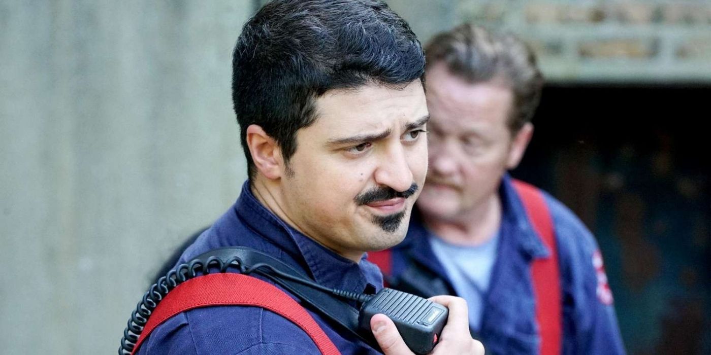 Yuri Sardarov as Brian 'Otis' Zvonecek stands in front of Christian Stolte as Randall 'Mouch' McHolland on Chicago Fire