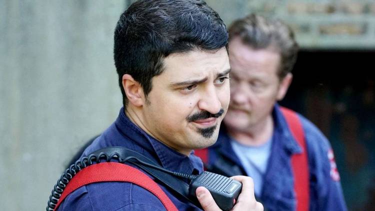 Yuri Sardarov as Brian 'Otis' Zvonecek stands in front of Christian Stolte as Randall 'Mouch' McHolland on Chicago Fire