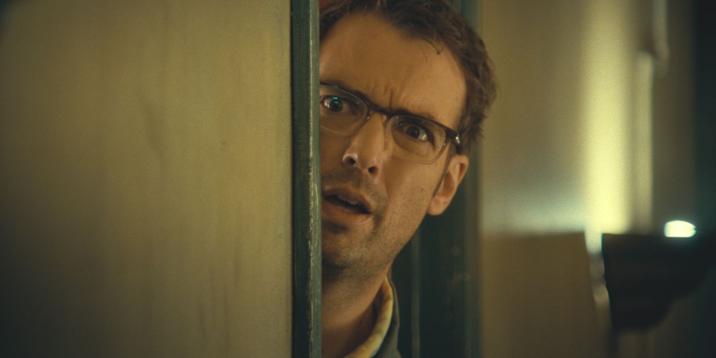 William (played by actor Jonah Ray) looks nervously behind his door in Destroy All Neighbors