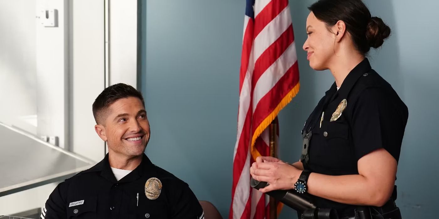 Eric Winter as Tim Bradford sits, looking up at Melissa O'Neil as Lucy Chen on The Rookie