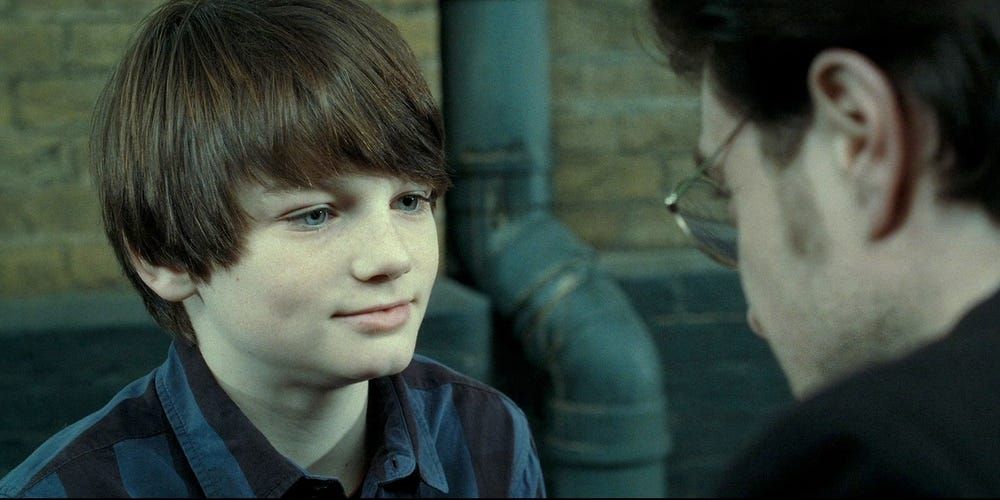 Harry Potter leaning down and talking to his son, Albus Severus Potter, at Platform 9 and 3/4.