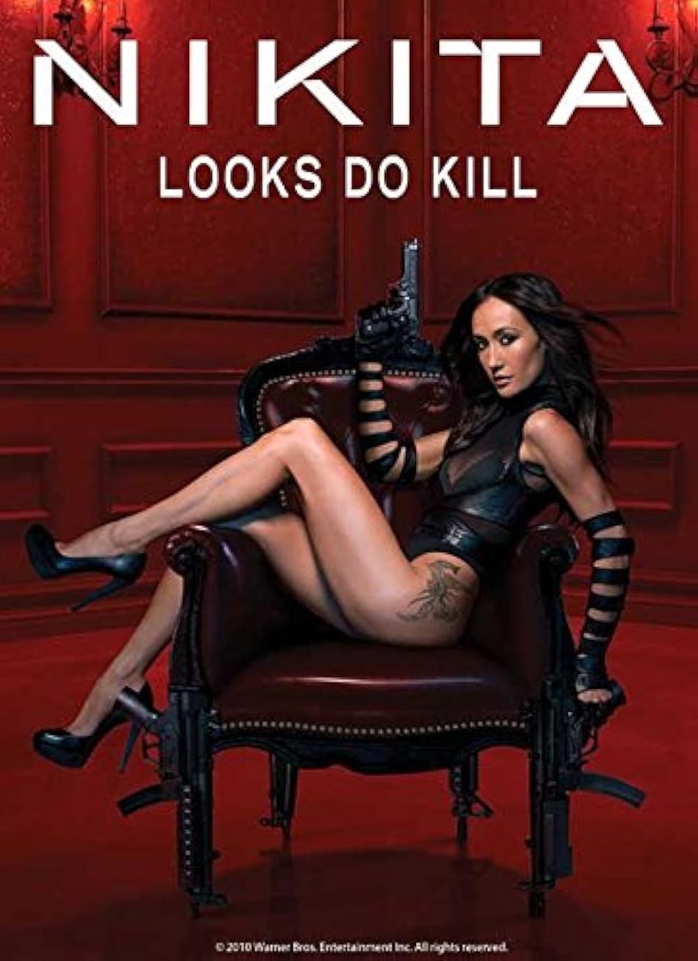 Maggie Q posing on a chair with a gun for the poster of Nikita