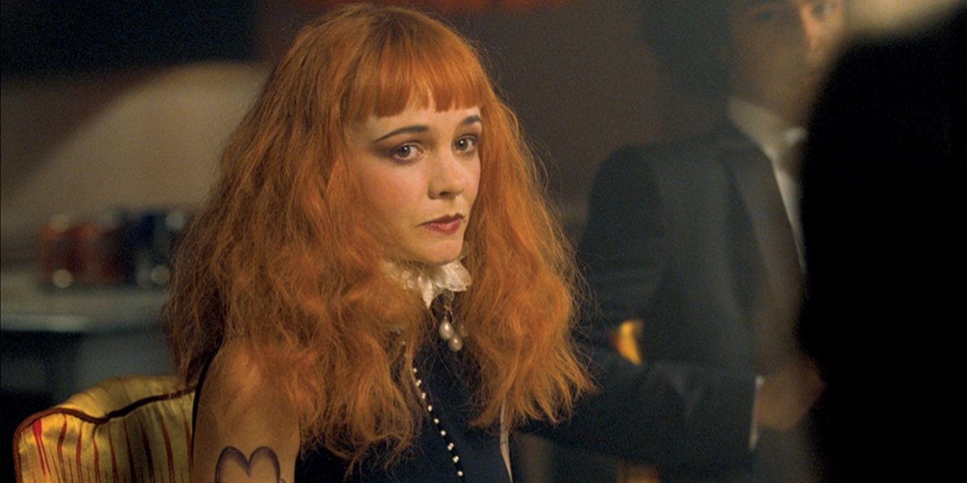 Carey Mulligan como a pobre querida Pamela está sentada parecendo preocupada à mesa de jantar em Saltburn