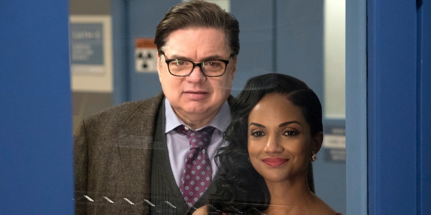 Oliver Platt as Daniel Charles stands behind Mekia Cox as Robin Charles on Chicago Med