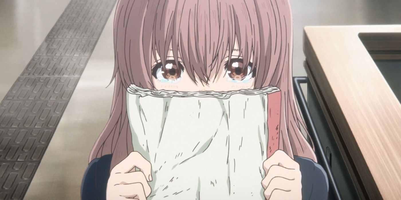 shoko nishimiya timidly peeks from behind her notebook