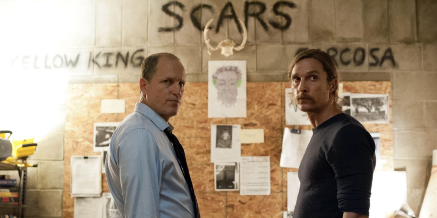 An older Rust Cohle and Marty Hart stand in front of an evidence board in True Detective