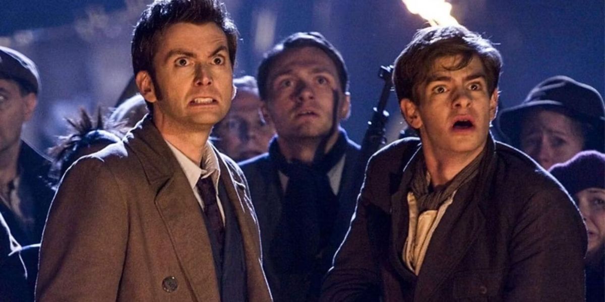 The Doctor (David Tennant) and Frank (Andrew Garfield) standing in a crowd looking at something with scared faces in Doctor Who Season 3