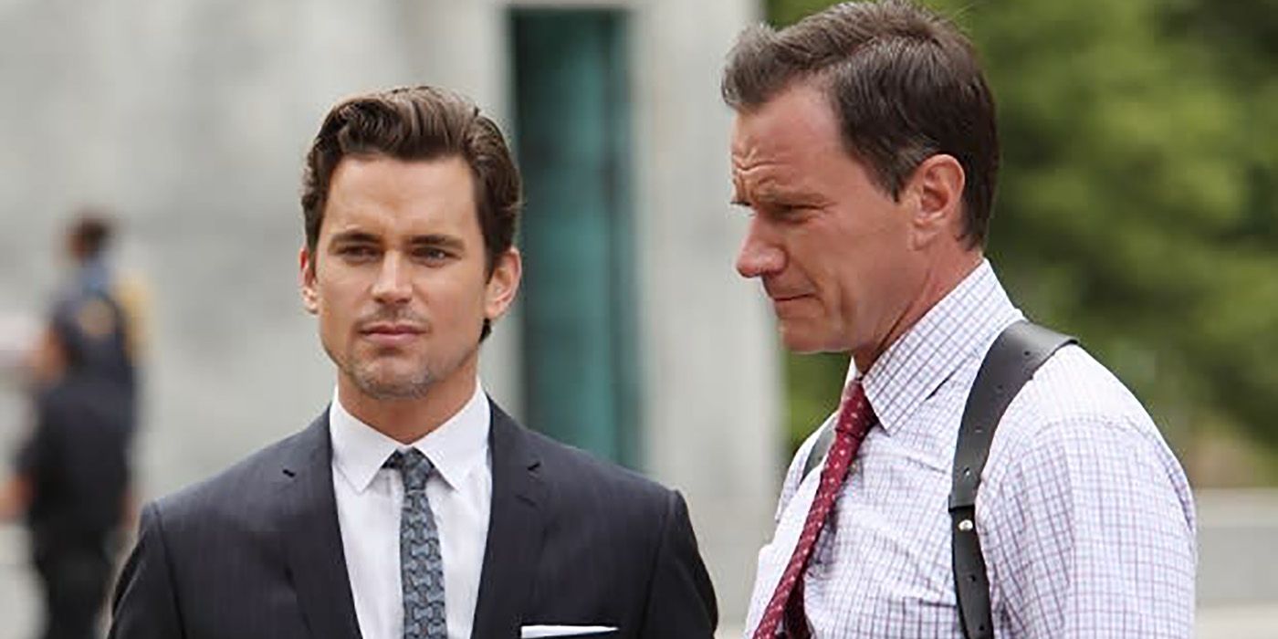 Two men in suits standing outside, one looking at the other in a scene from White Collar.