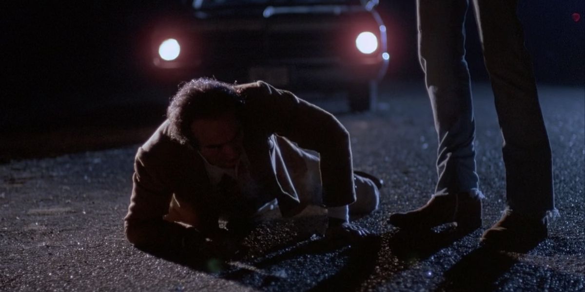 Um homem tenta rastejar para longe de seu agressor no filme Blood Simple