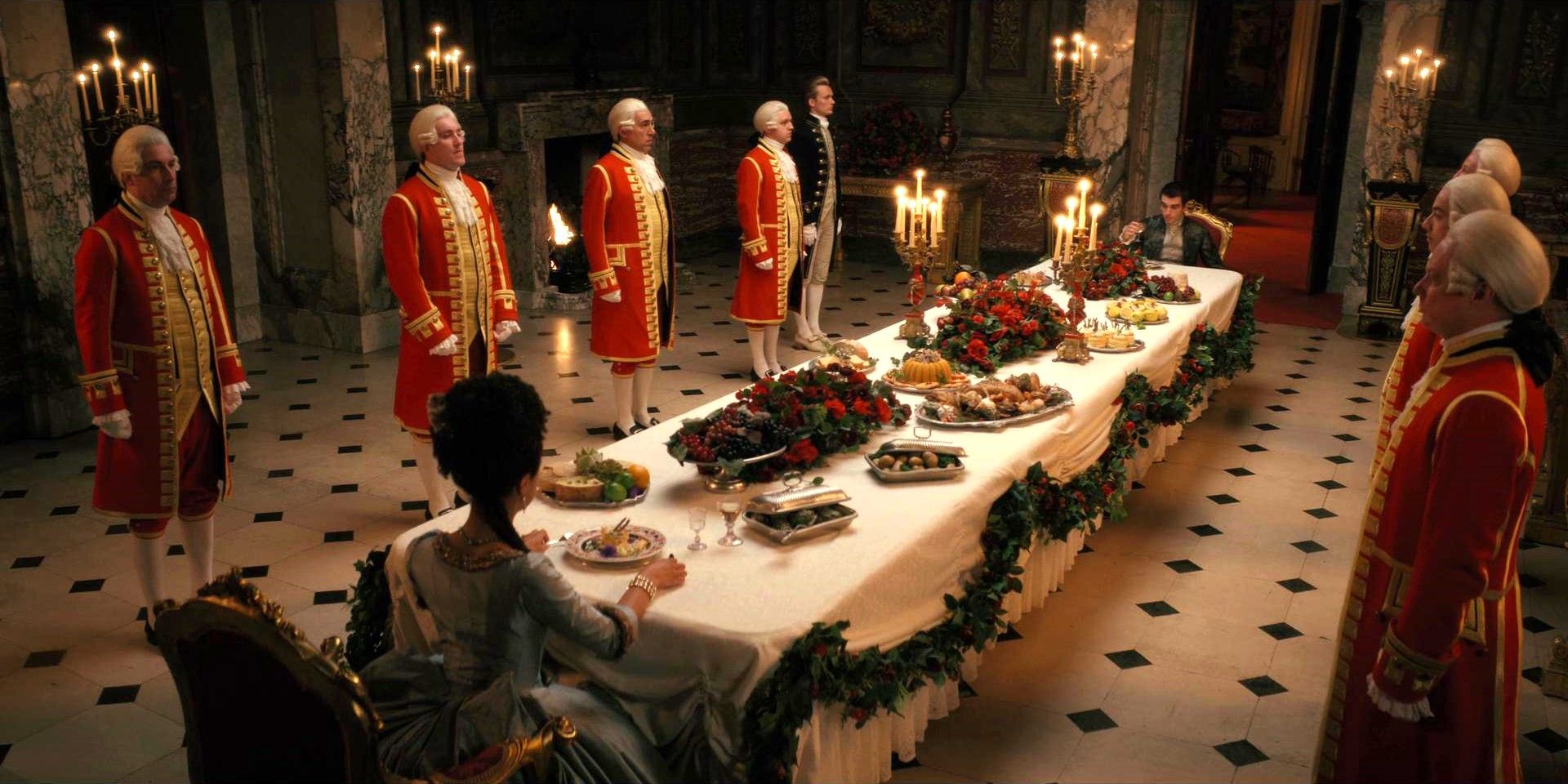 King George and Queen Charlotte sit at the dining table in Queen Charlotte: A Bridgerton Story.