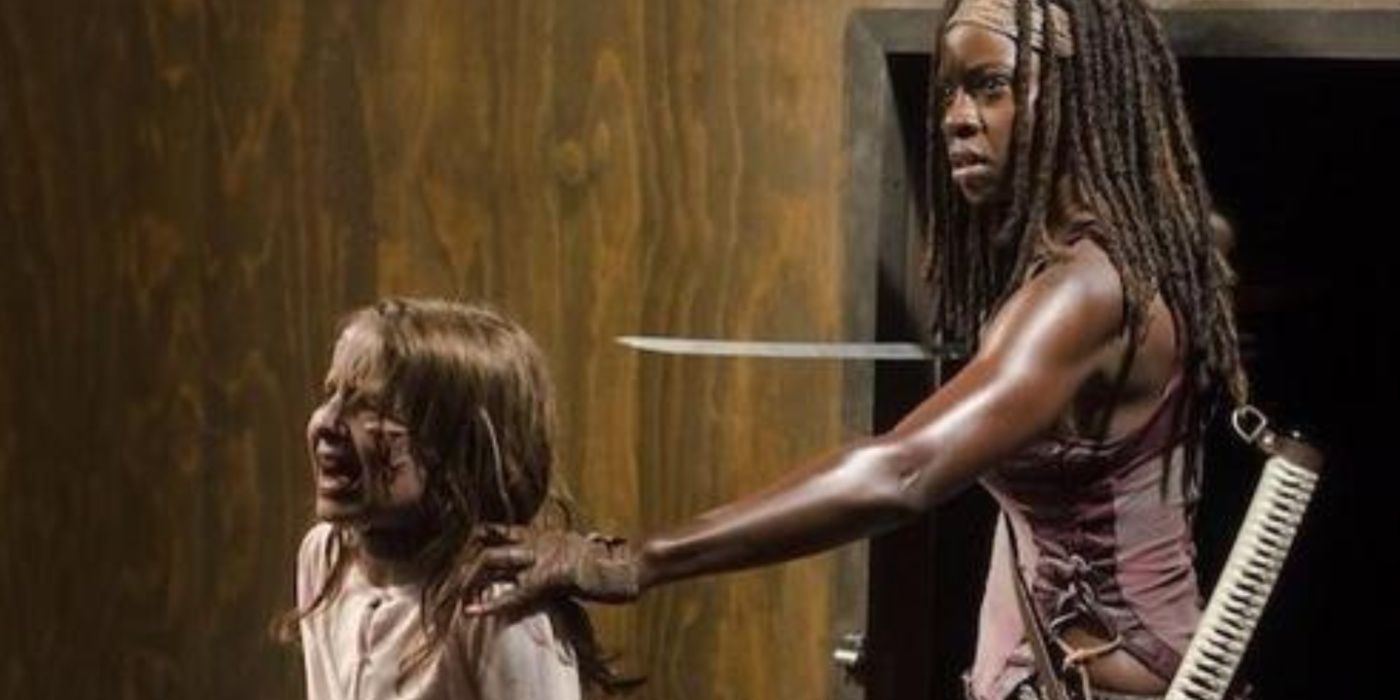 Michonne holding her katana to the Governor's undead child in The Walking Dead. 